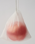 a pink ball of body soap in a mesh bag