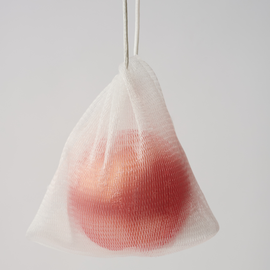 a pink ball of body soap in a mesh bag